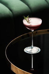 Classic cocktail glass on glass table in night club restaurant, close-up