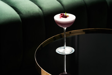Classic cocktail glass on glass table in night club restaurant, close-up
