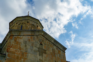 Fototapeta premium Gergeti Trinity Church, Georgia. Sunrise at the Gergeti Trinity Church with sunrays at chapel at the foot of Kazbegi mountain near Stepantsminda