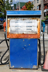 Fototapeta na wymiar Close up of a rusting vintage gas pump at an urban service station.