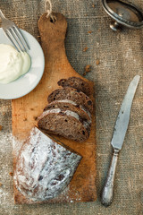 Freshly baked wheat bread, homemade cakes, still life with bread, crisp loaf of bread, still life on a rustic background, top view, rustic bread, roll, loaf.