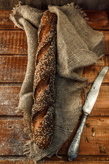 Freshly baked wheat bread, homemade cakes, still life with bread, crisp loaf of bread, still life on a rustic background, top view, rustic bread, roll, loaf.