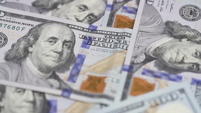 Hundred dollar bills spinning on a table. Close-up. Rotation paper money close-up. Background with money american hundred dollar bills