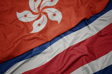 waving colorful flag of costa rica and national flag of hong kong.