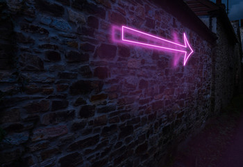 Pink neon arrow against a brick wall with glowing shadows and light