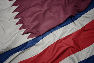 waving colorful flag of costa rica and national flag of qatar.