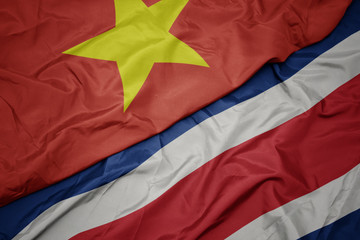waving colorful flag of costa rica and national flag of vietnam.