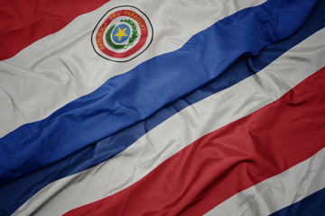 Fototapeta premium waving colorful flag of costa rica and national flag of paraguay.