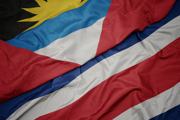 waving colorful flag of costa rica and national flag of antigua and barbuda.