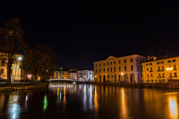 Fototapeta premium Widok na rzekę Sile z mostem uniwersyteckim Ponte Dell Universita i uniwersytet w tle nocą Treviso Włochy
