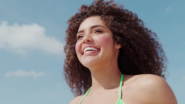 Black beautiful attractive afro young cute girl, curly hair, bikini, famous beach Rio de Janeiro, Brazil. Latin summer vacation holiday. Cinematic 4K.