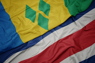 waving colorful flag of costa rica and national flag of saint vincent and the grenadines.