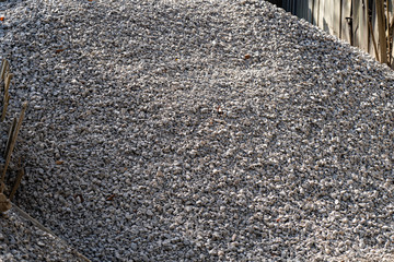 A large pile of bulk 57 gravel sits ready to be used on a job site for a DIY home improvement...