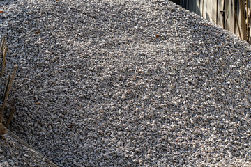 A large pile of bulk 57 gravel sits ready to be used on a job site for a DIY home improvement project