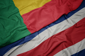 waving colorful flag of costa rica and national flag of benin.