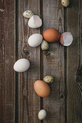 Chicken eggs. Minimalistic still life on a dark old vintage wooden background. Top view Selective focus. Cardboard packaging for eggs.