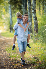 Fototapeta premium Father and son having fun in the park on a sunny day