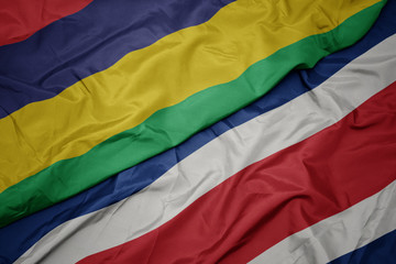 waving colorful flag of costa rica and national flag of mauritius.