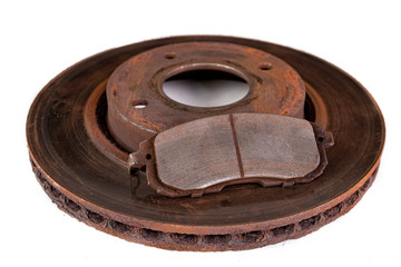 Old rusty brake disc and worn block. Used spare parts for passenger cars.