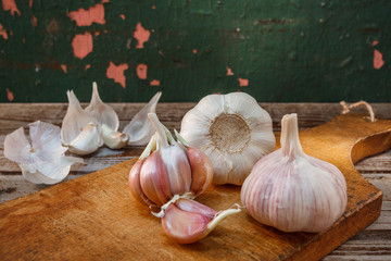 Fresh garlic, head of garlic, bulb of garlic, cloves of garlic on an old rustic wooden background. Place for text. The concept of a healthy diet. Vitamins.