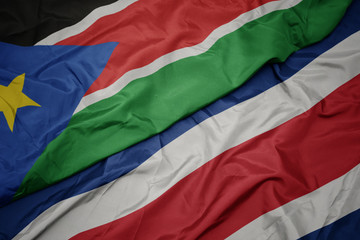 waving colorful flag of costa rica and national flag of south sudan.
