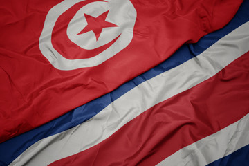 waving colorful flag of costa rica and national flag of tunisia.