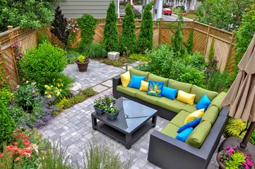 Tuinposter A beautiful small, urban backyard garden featuring a tumbled paver patio, flagstone stepping stones, and a variety of trees, shrubs and perennials add colour and year round interest.  © Joanne Dale