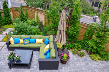 A beautiful small, urban backyard garden featuring a tumbled paver patio, flagstone stepping...