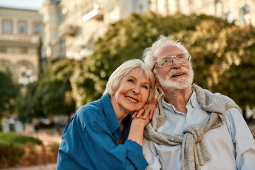 Endless love. Portrait of beautiful senior woman leaning at shoulder of her husband and smiling while spending time together outdoors on a sunny day