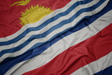 waving colorful flag of costa rica and national flag of Kiribati .