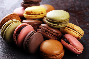 Sweet and colourful french macaroons or macaron on dark black background, Dessert.