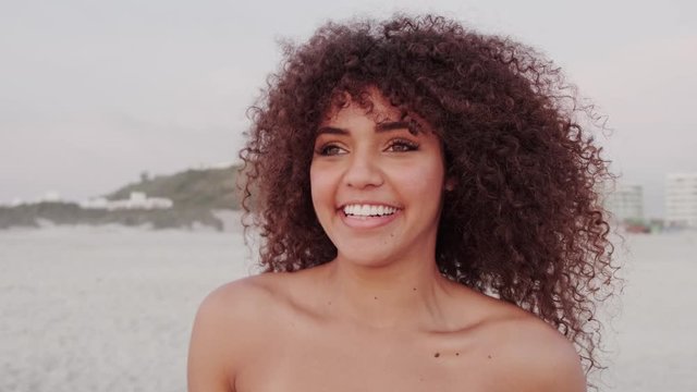 Black beautiful attractive afro young cute girl, curly hair, bikini, famous beach Rio de Janeiro, Brazil. Latin summer vacation holiday. Cinematic 4K.