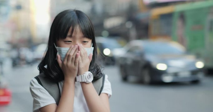 Little girl wearing mask and cough at the road. Health care and medical concept.