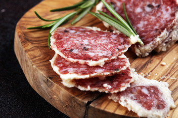 Salami truffle. The saltufo is a piece of salami mixed with summer truffle on rustic background