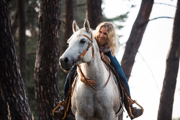 Frau lehnt sich im Gelände auf den Pferdehals und schaut während des Ausritts gemeinsam in die Ferne © Talitha