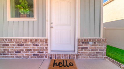 Panorama frame Front door and porch of home with hello mat