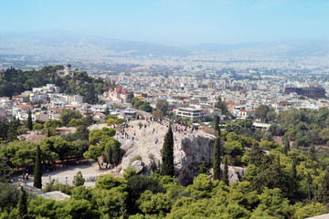 Fototapeta na wymiar View from Acropolis. St. Marei church to the left. Tourists taking photos of the Acropolis from a distance. View of the capital in the background.