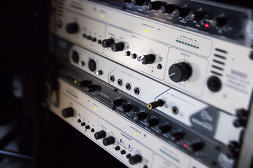 A rack of audio compressors in a recording studio.