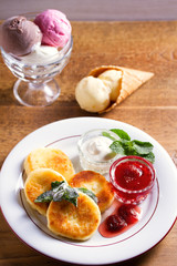 Homemade cottage cheese pancakes. Syrniki (popular dish in Russia and Ukraine) with fresh mint, sour cream and strawberry jam, ice cream - dessert concept