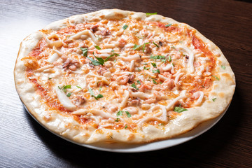 Cheap pizza with chicken, squid, herbs.