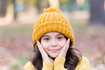 Autumn skin care. Little child wear hat on autumn landscape. Small girl touch clean pure skin. Organic cosmetics for skin. Natural beauty. Adapt kids skin for autumn weather
