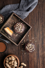 Cold crunchy treat, chocolate cups with caramel and peanut butter filling, sprinkled with chopped nuts