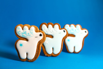 gingerbread cookie of cute deer on blue background. Traditional Christmas food. Christmas and New Year holiday concept.
