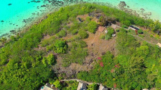 Aerial of the remains of a burnt down hut on a tropical island, drone flying forward - Bora Bora, French Polynesia