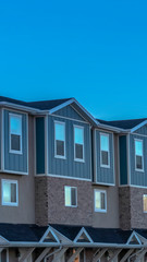 Vertical frame Close up of the upper storey of townhomes with clear blue sky background