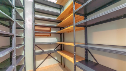 Panorama frame Interior of a small empty closet with metal and wood shelves for clothes