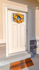 Vertical frame Front door of modern home with sunflower wreath