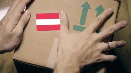Labeling carton with the Austrian flag sticker. Import or export in Austria related clip - Powered by Adobe