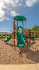 Vertical frame Slides with climbig bars at a playground under blue sky on a sunny day