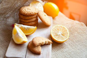 lemon gingerbread cookies lie on a wooden board on a rustic table, still life of fresh biscuits with citrus, copy space